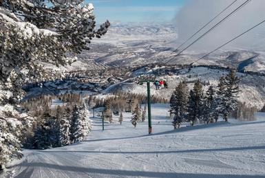 Ski lift with riders headed up the mountain.