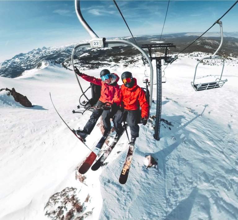 Two skiers riding a chairlift.