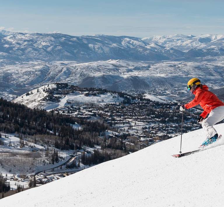 Skier descends mountain overlooking Deer Valley Resort.