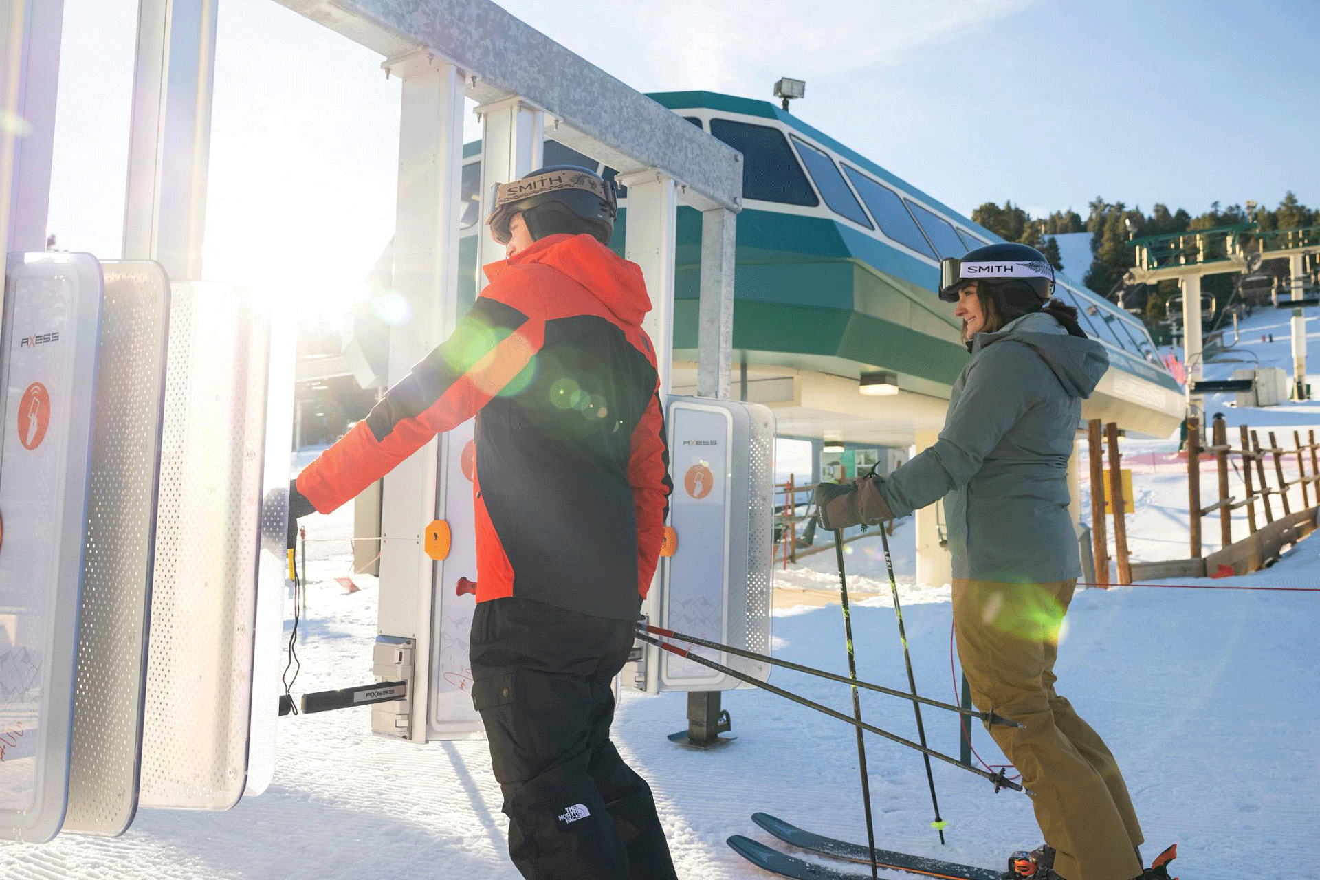 A male and female skier getting ready to go through the RFID gates to head towards the chairlifts at Snow Summit