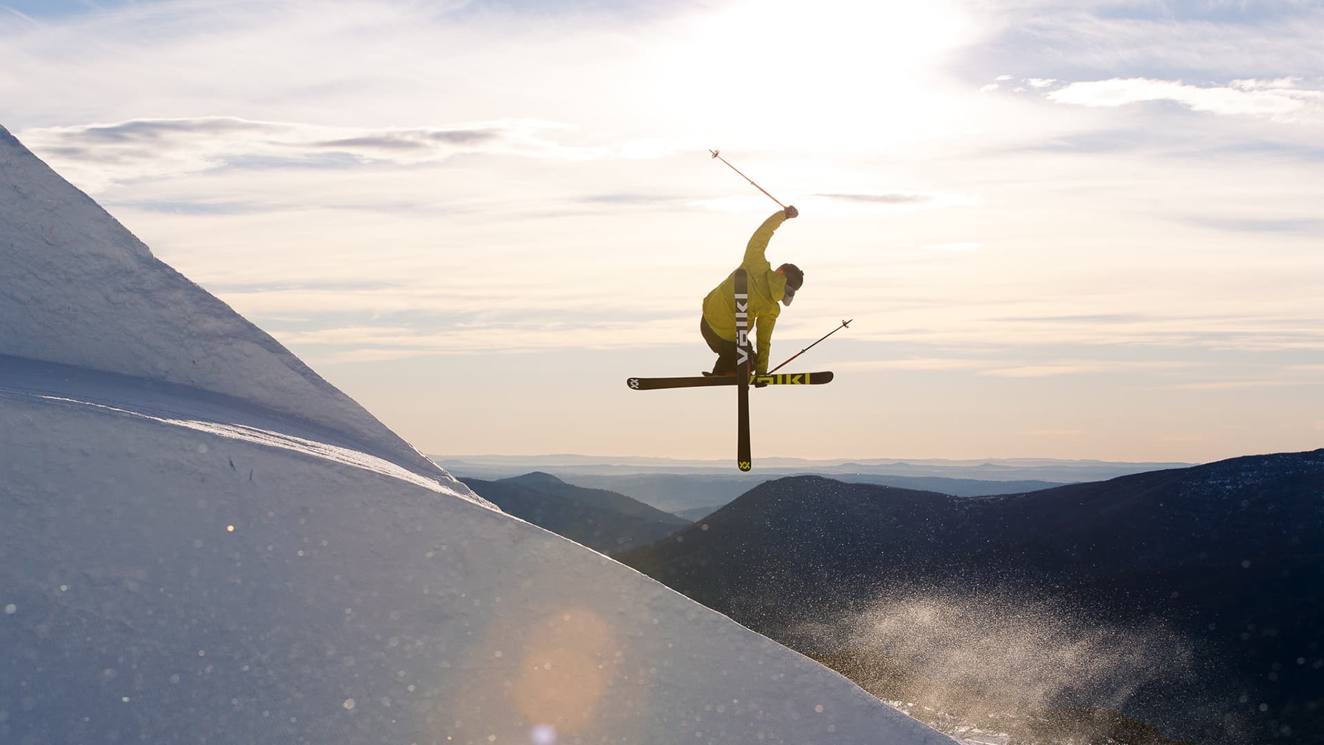 Dynamic shot of a skier suspended mid-air against a snowy backdrop.