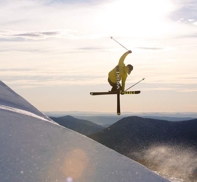 Dynamic shot of a skier suspended mid-air against a snowy backdrop.