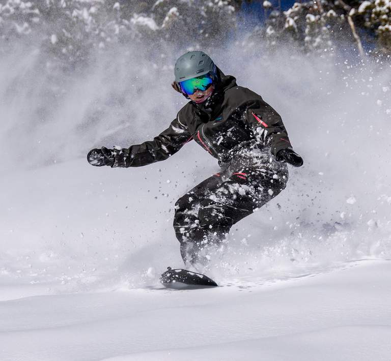 Snowboarder going through powder