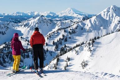 Two skiers taking in a scenic mountain view.