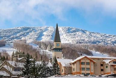 Snow covered town with mountains in the background.