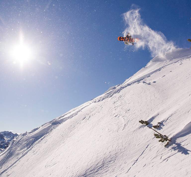 An impressive aerial maneuver by a snowboarder catching big air.
