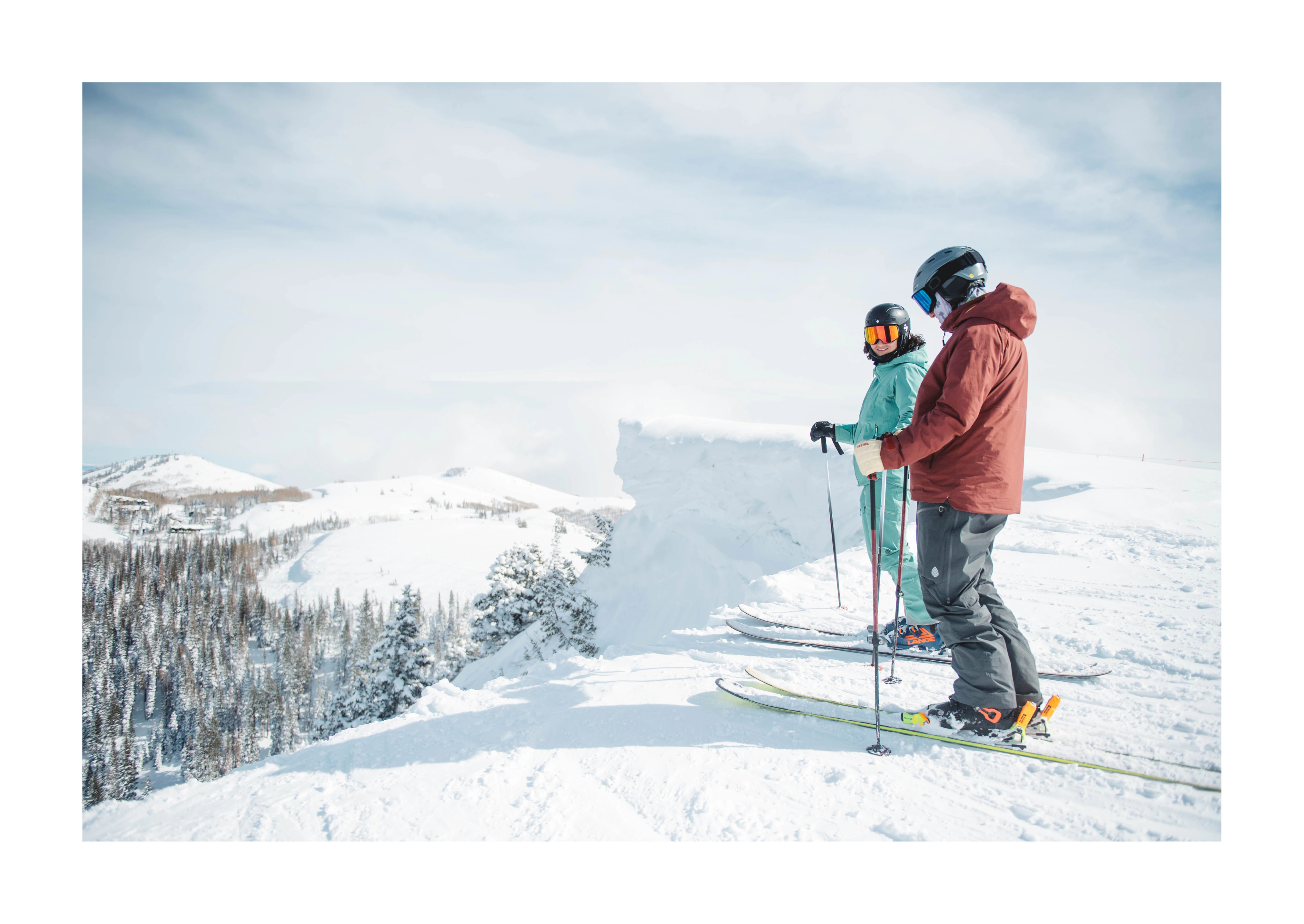 Two skiiers standing on the edge of a mountain