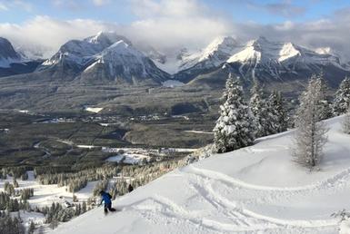 Snowboarder carving through deep untouched snow.