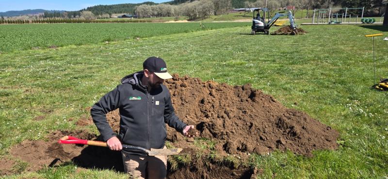 Inspecting a test hole during soil profile evaluation