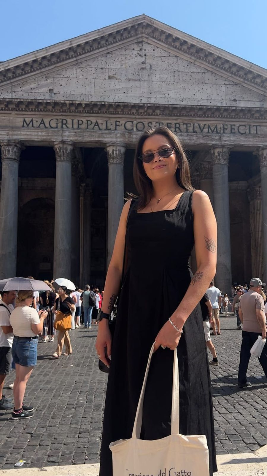 Linda standing in front of a classical stone portico in a long black dress