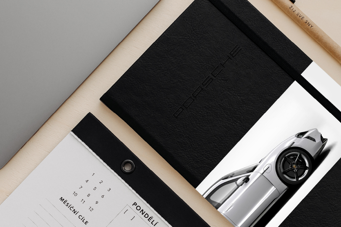 Black planner with an embossed Porsche logo, pencil and planning pad