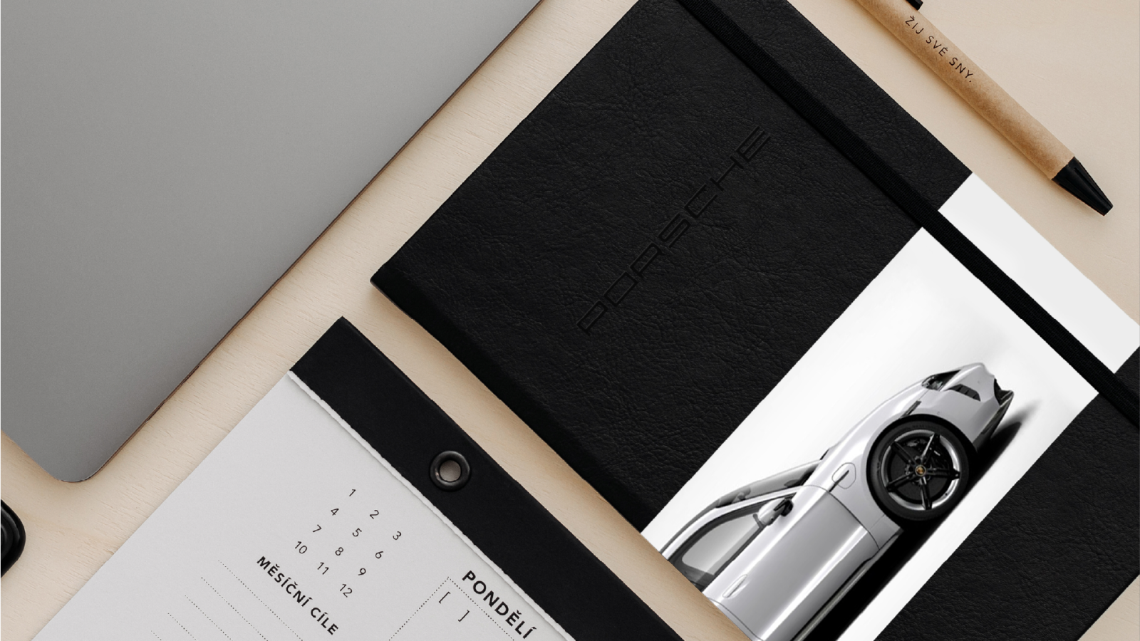 Black planner with an embossed Porsche logo, pencil and planning pad