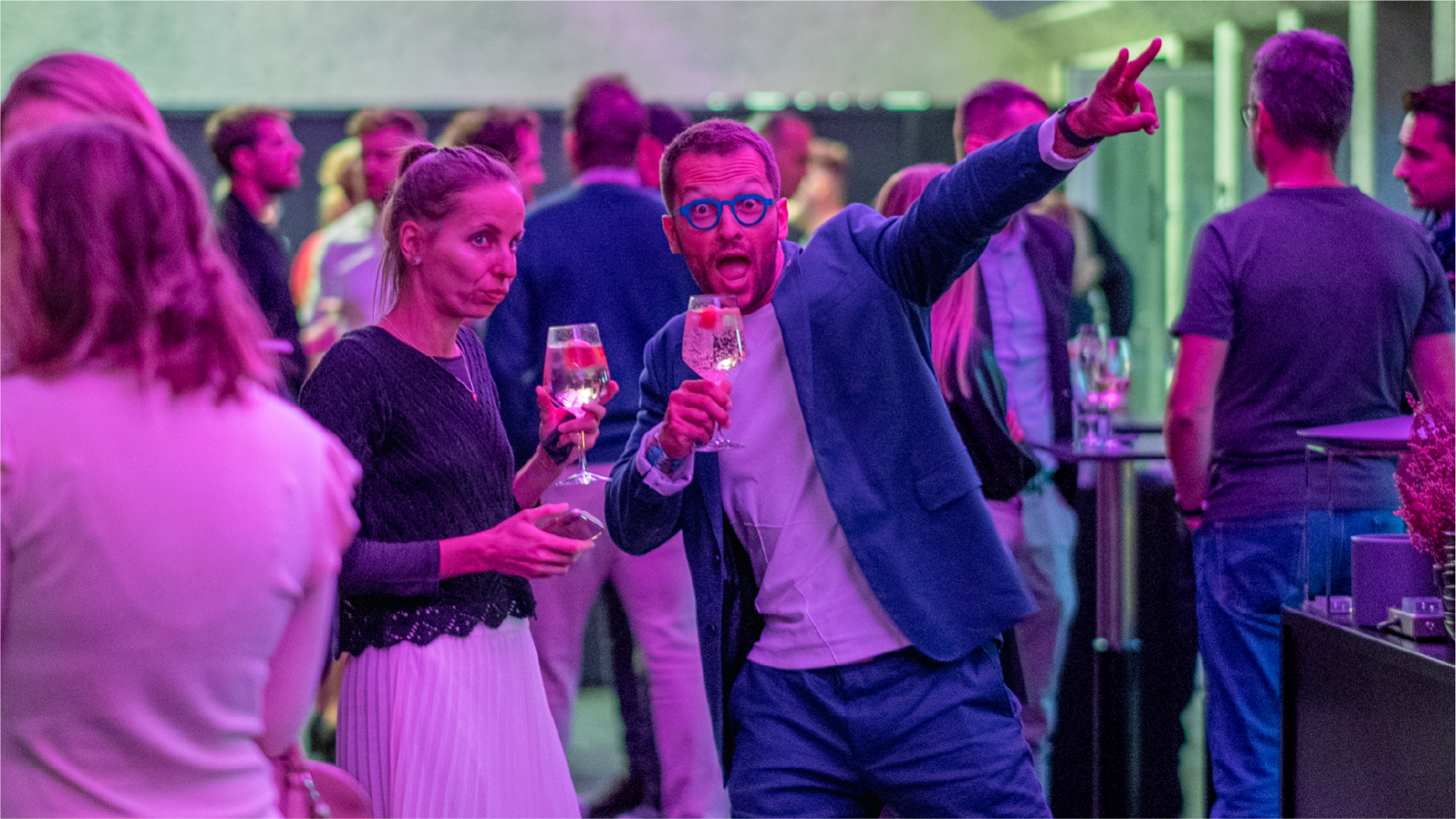 Guests with drinks at the Hearts & Science launch event under purple lighting