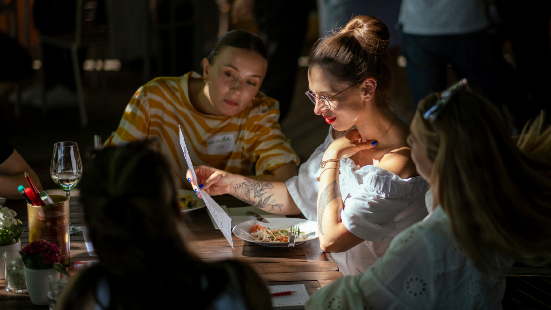Guests at dinner looking at drawings created during the event