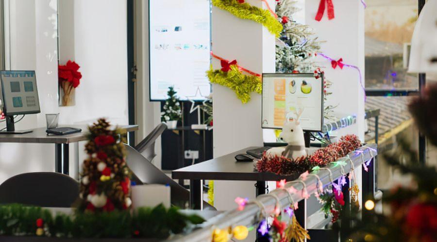 Kantoor met kerstversiering: lichtslingers, kerstbomen en slingers langs de werkplekken