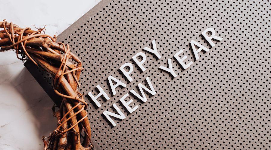 Houten krans en de letters Happy New Year op een grijze plaat