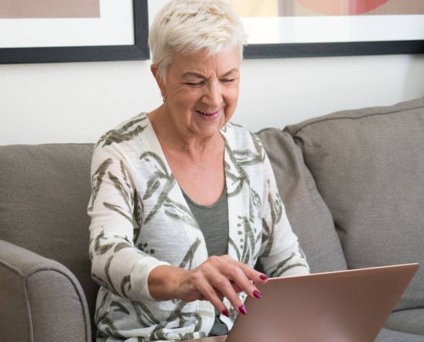 Babyboomer kijkt op laptop