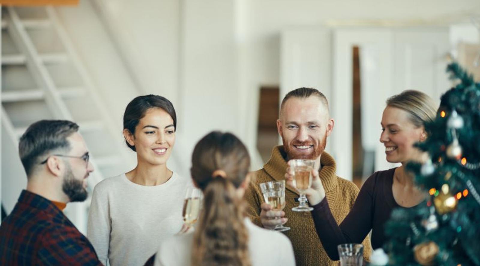 Collega's van verschillende leeftijden in gesprek tijdens een eindejaarsborrel