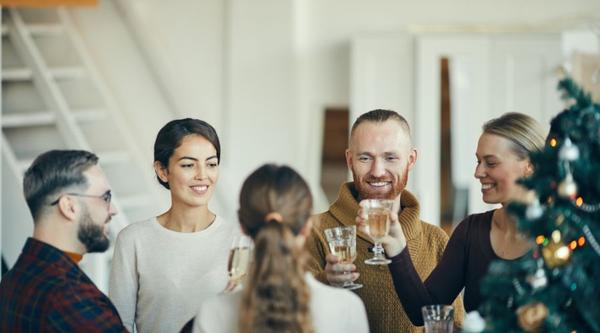 Collega's van verschillende leeftijden in gesprek tijdens een eindejaarsborrel