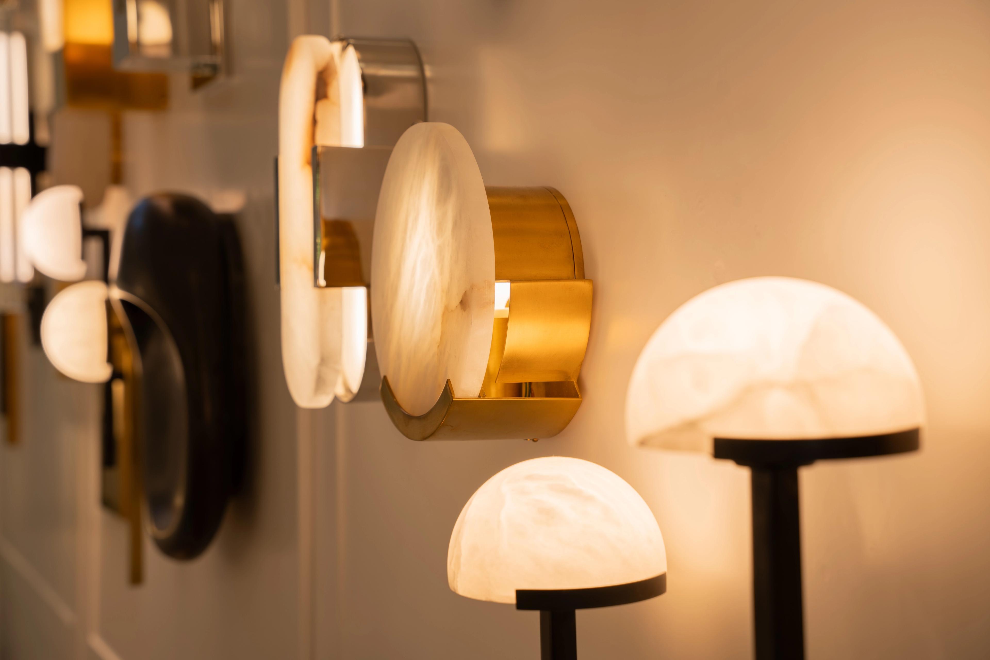 Alabaster and brass wall lights glowing in a row