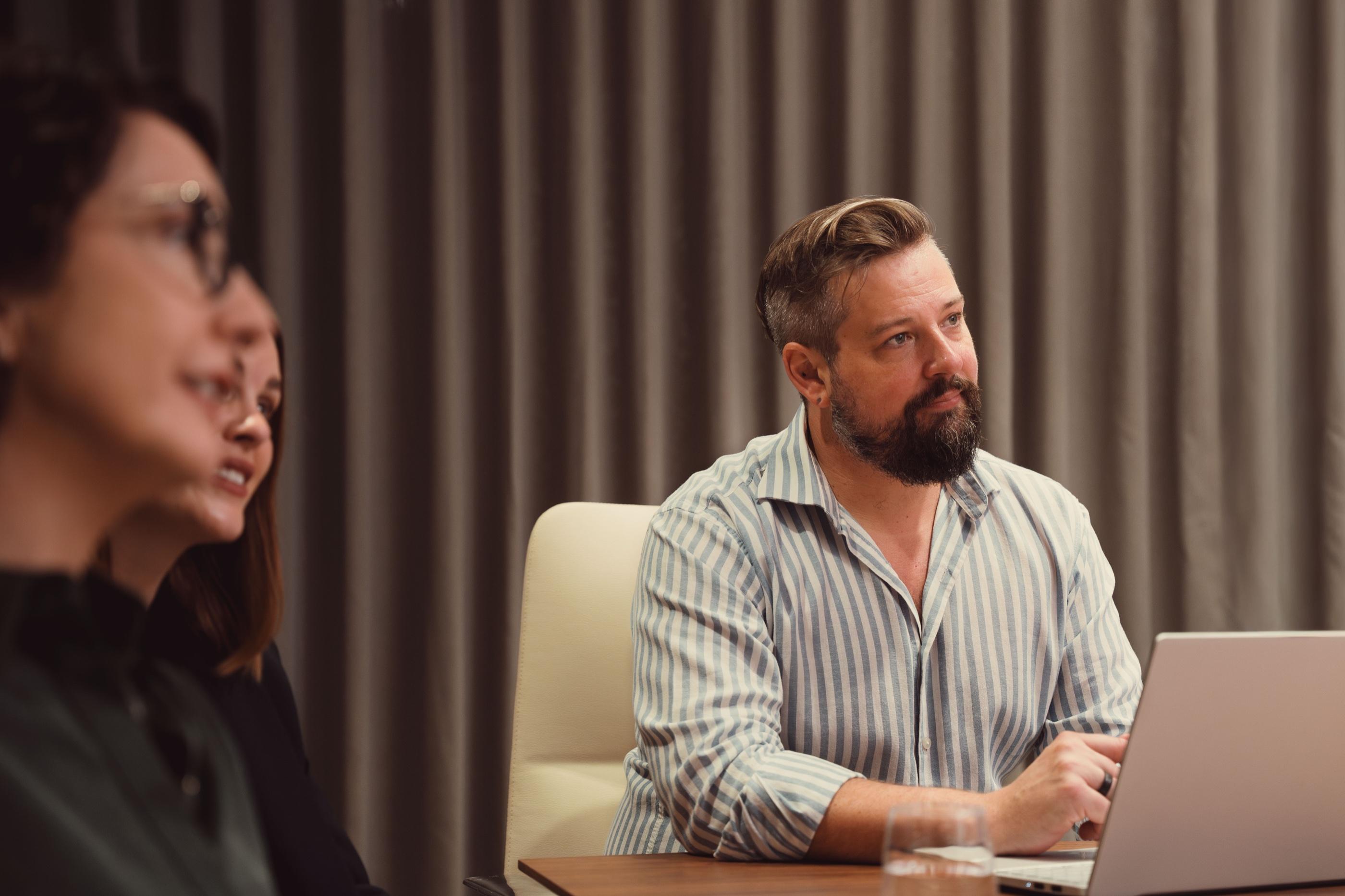 An AKT Advisory partner smiling across a meeting table