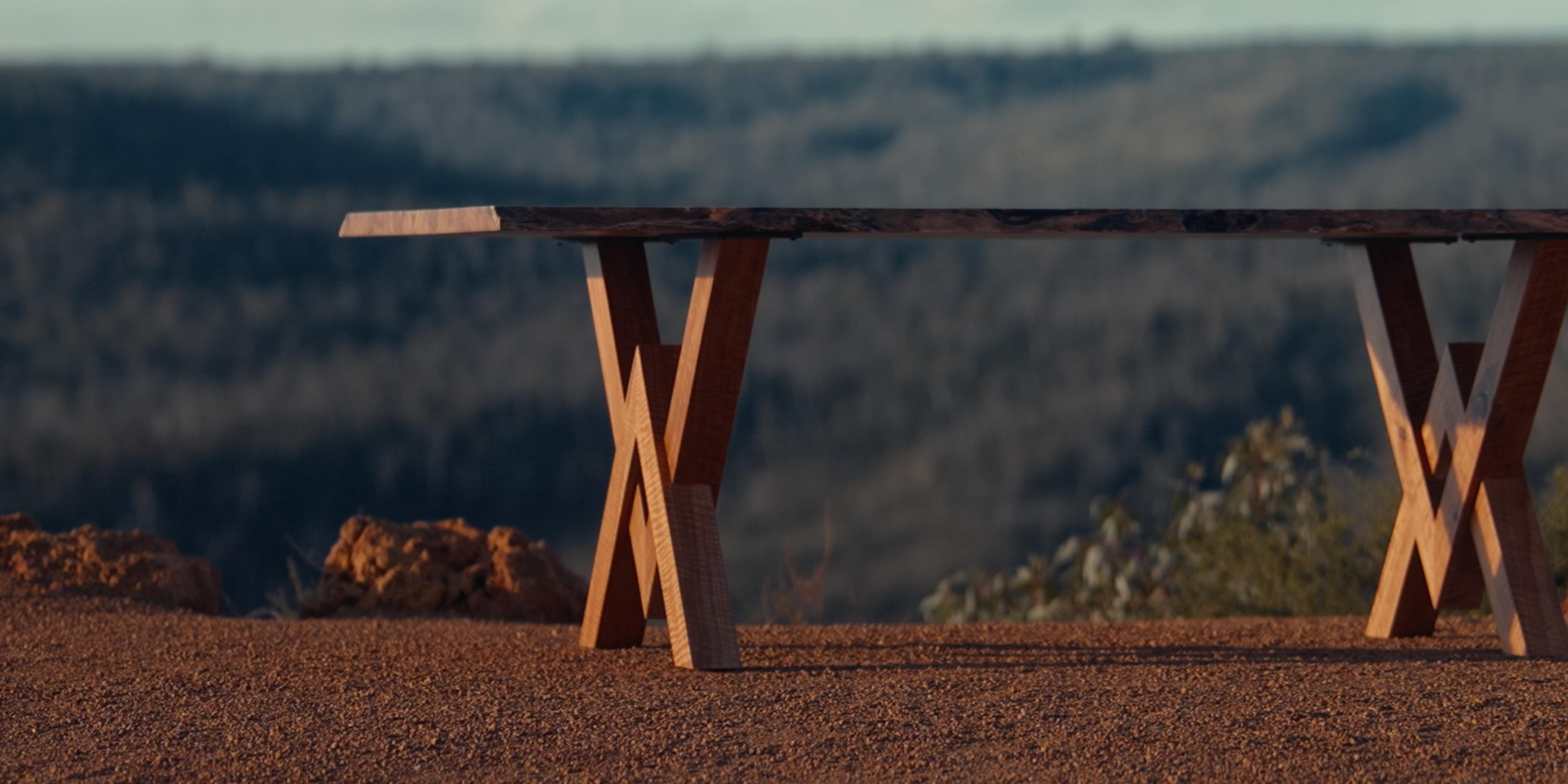 Nova living edge dining table on a ridge above a forested valley