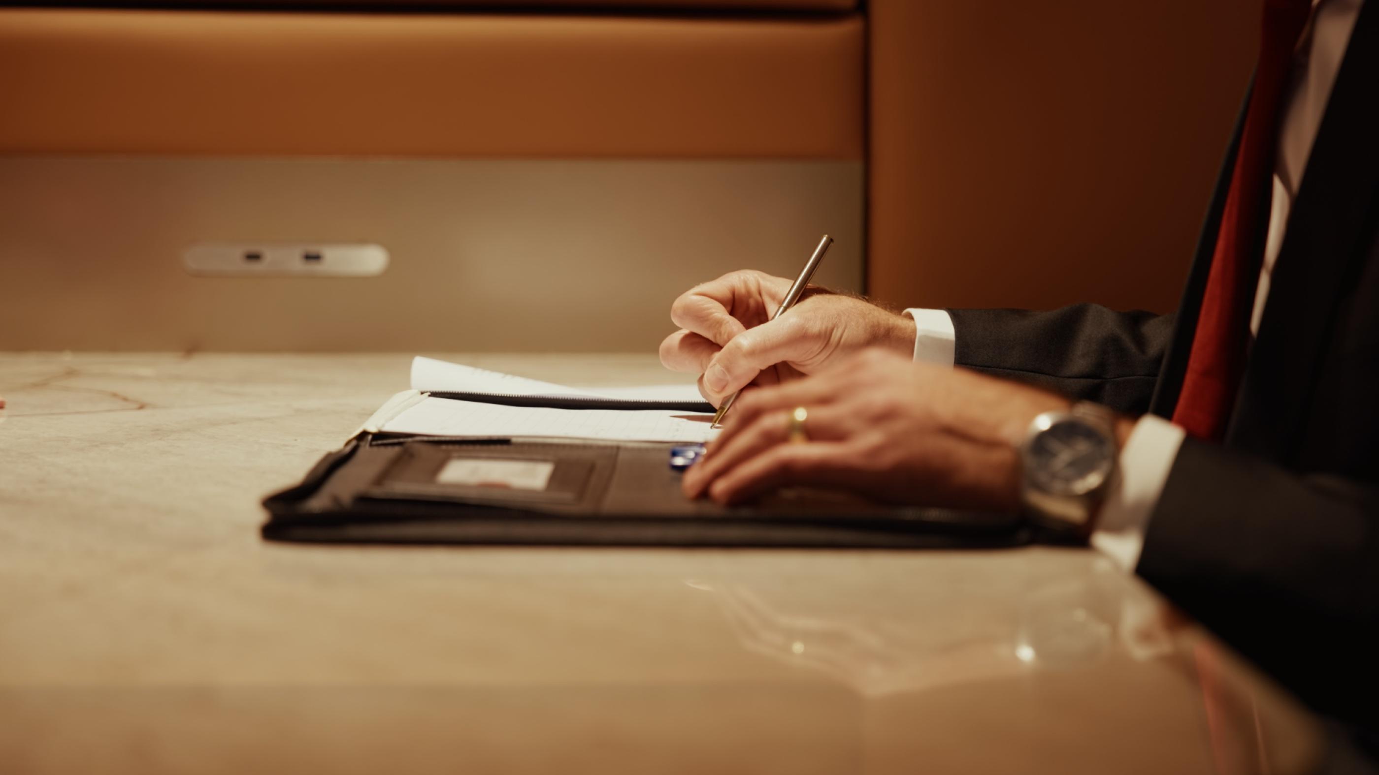 A lawyer signing documents at a marble table