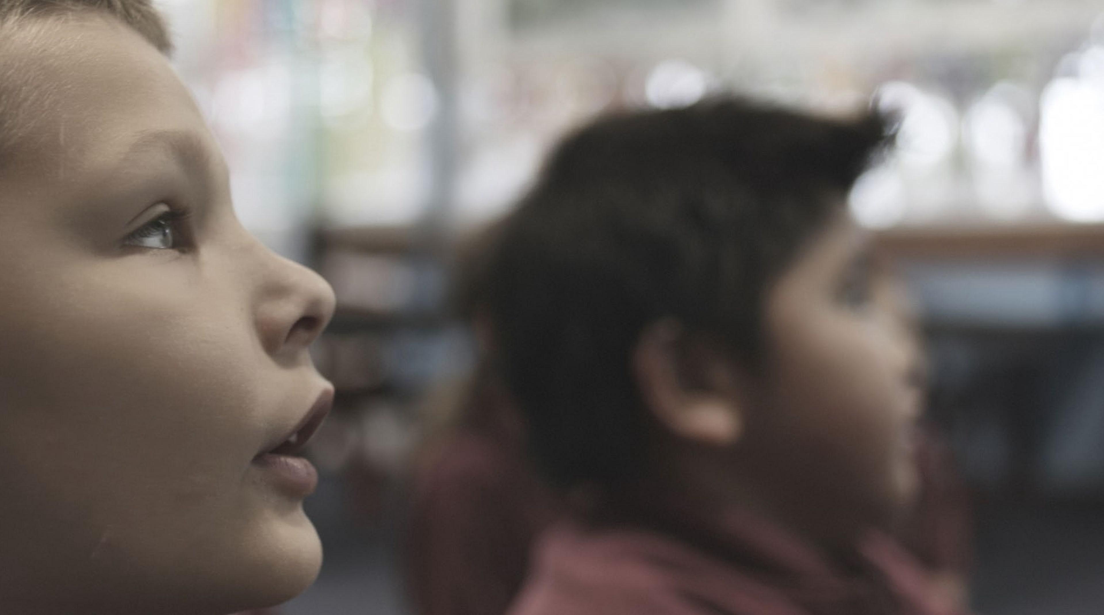 Two young students looking up in a classroom