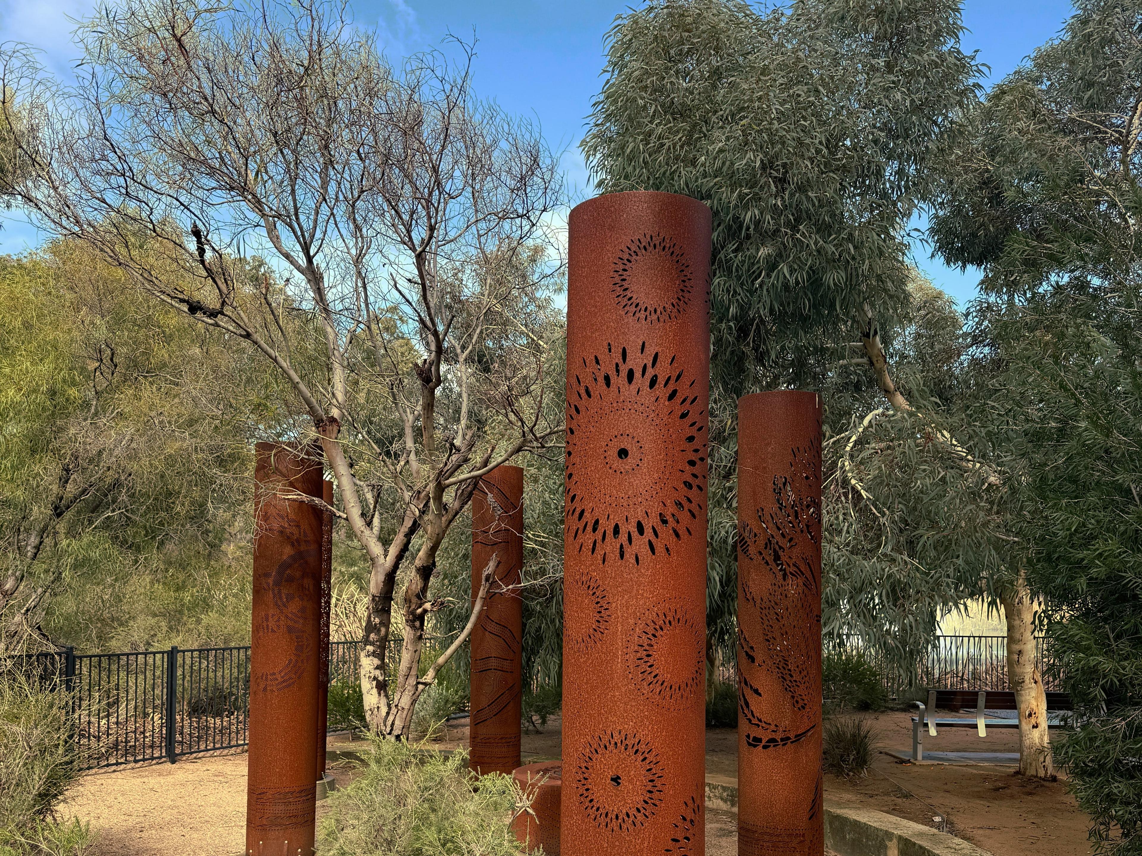 Five corten steel totems in a curved garden bed in the Fiona Stanley Hospital gardens