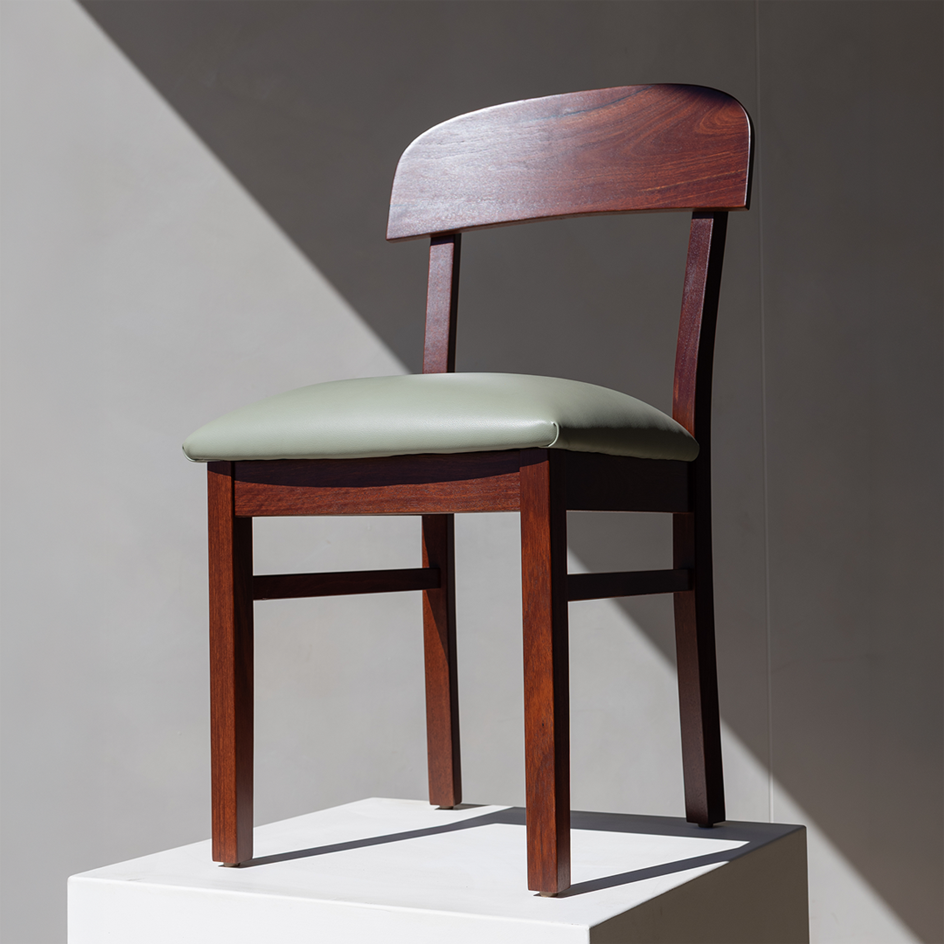 Carousel ad card: the Dongara dining chair in hard afternoon light