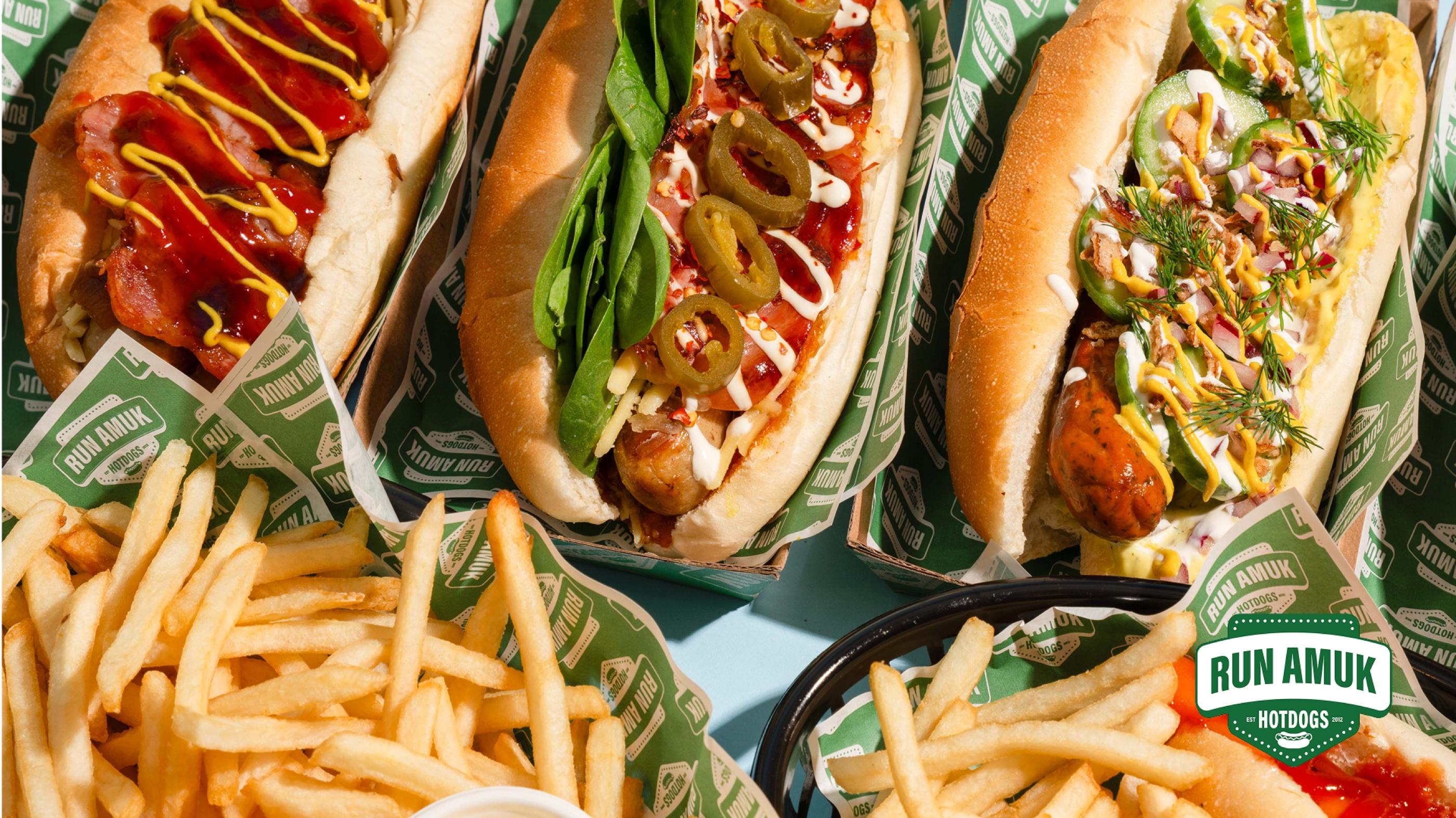 A spread of Run Amuk hotdogs and fries on branded tray paper
