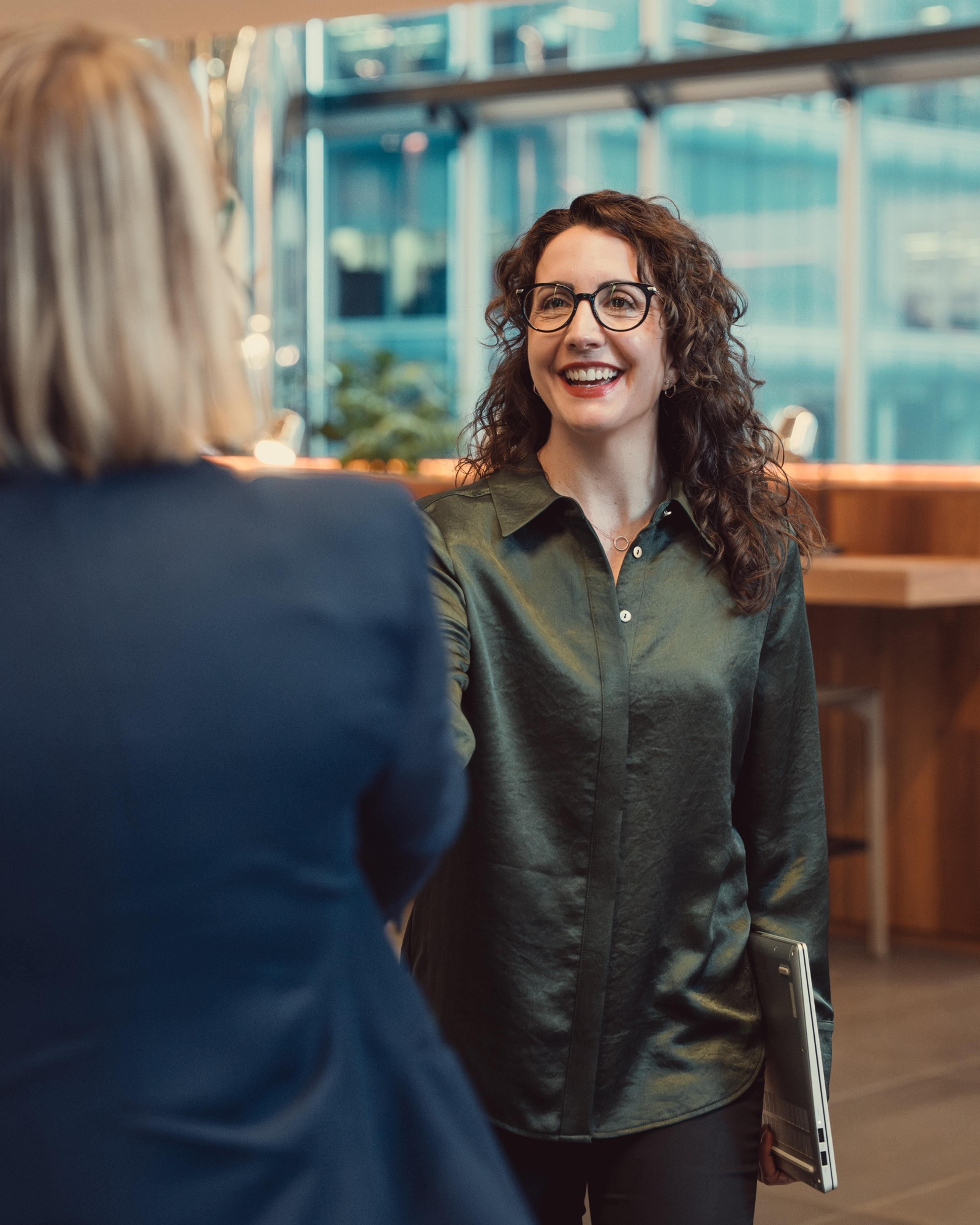 An AKT Advisory partner smiling as she greets a client
