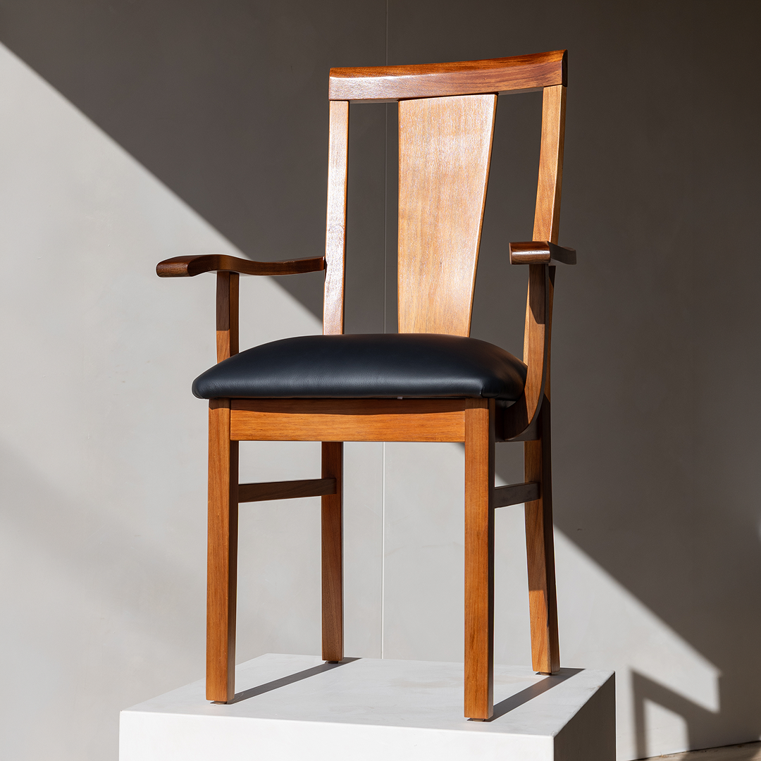 Carousel ad card: the Newman carver dining chair in hard afternoon light