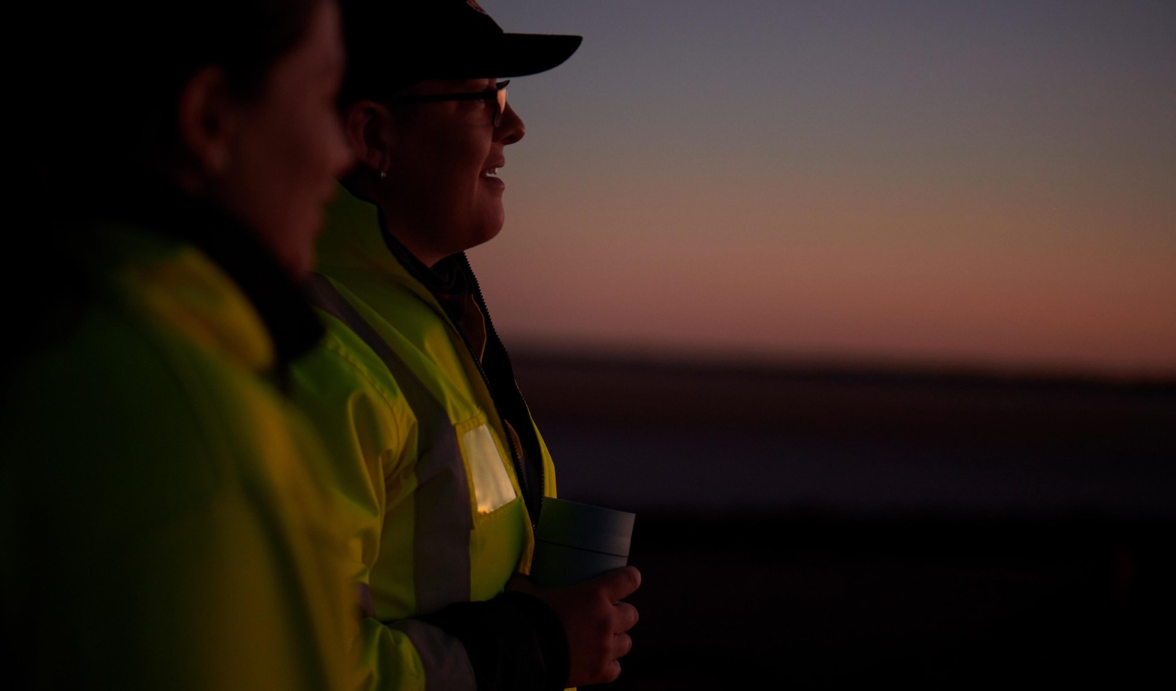 Two workers in hi-vis at dawn