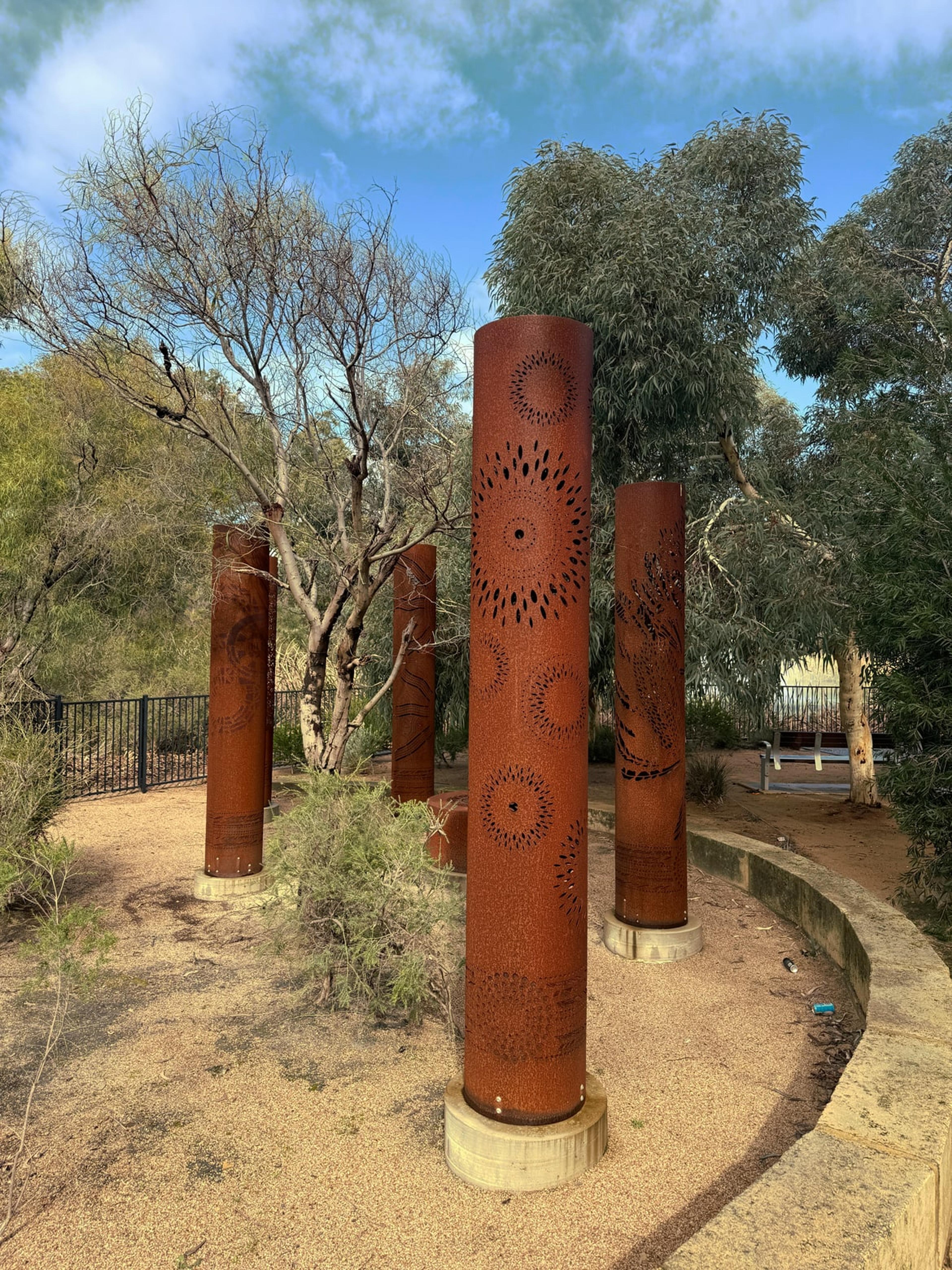 Five corten steel totems in a curved garden bed in the Fiona Stanley Hospital gardens