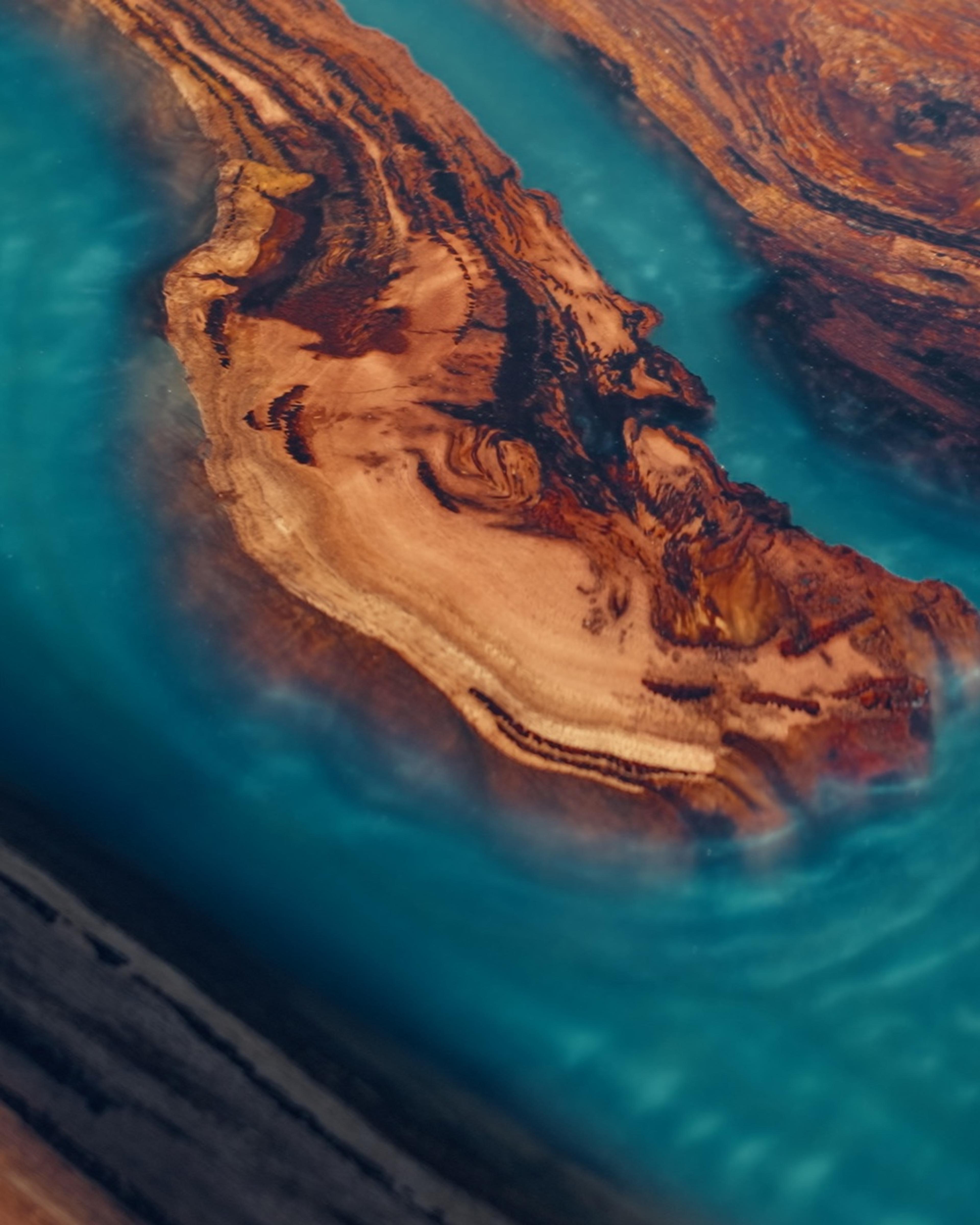 Teal resin river running through a Marri table top, from the Provenance film