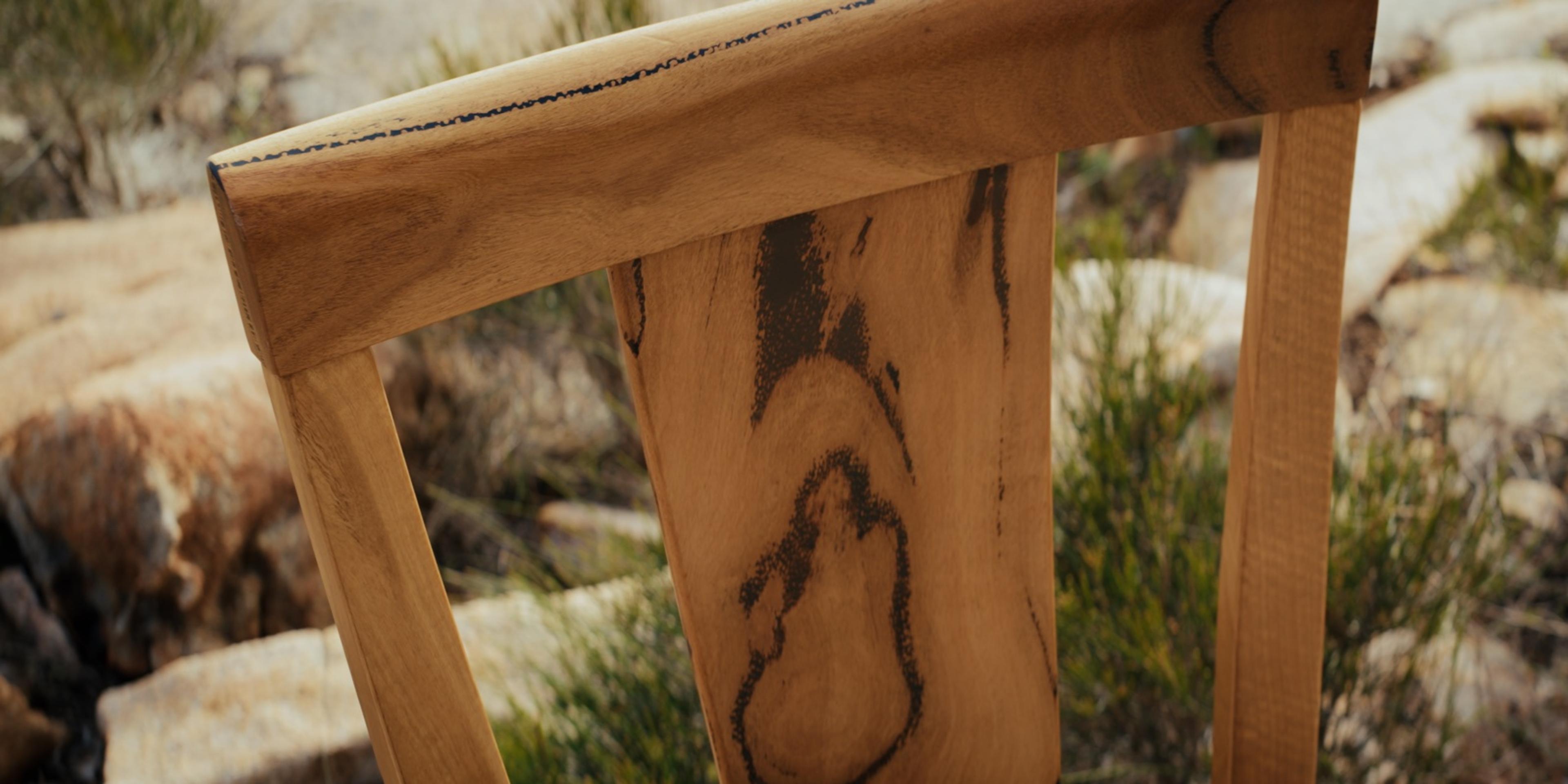 The figured Marri back of a Jurien Bay dining chair among granite boulders