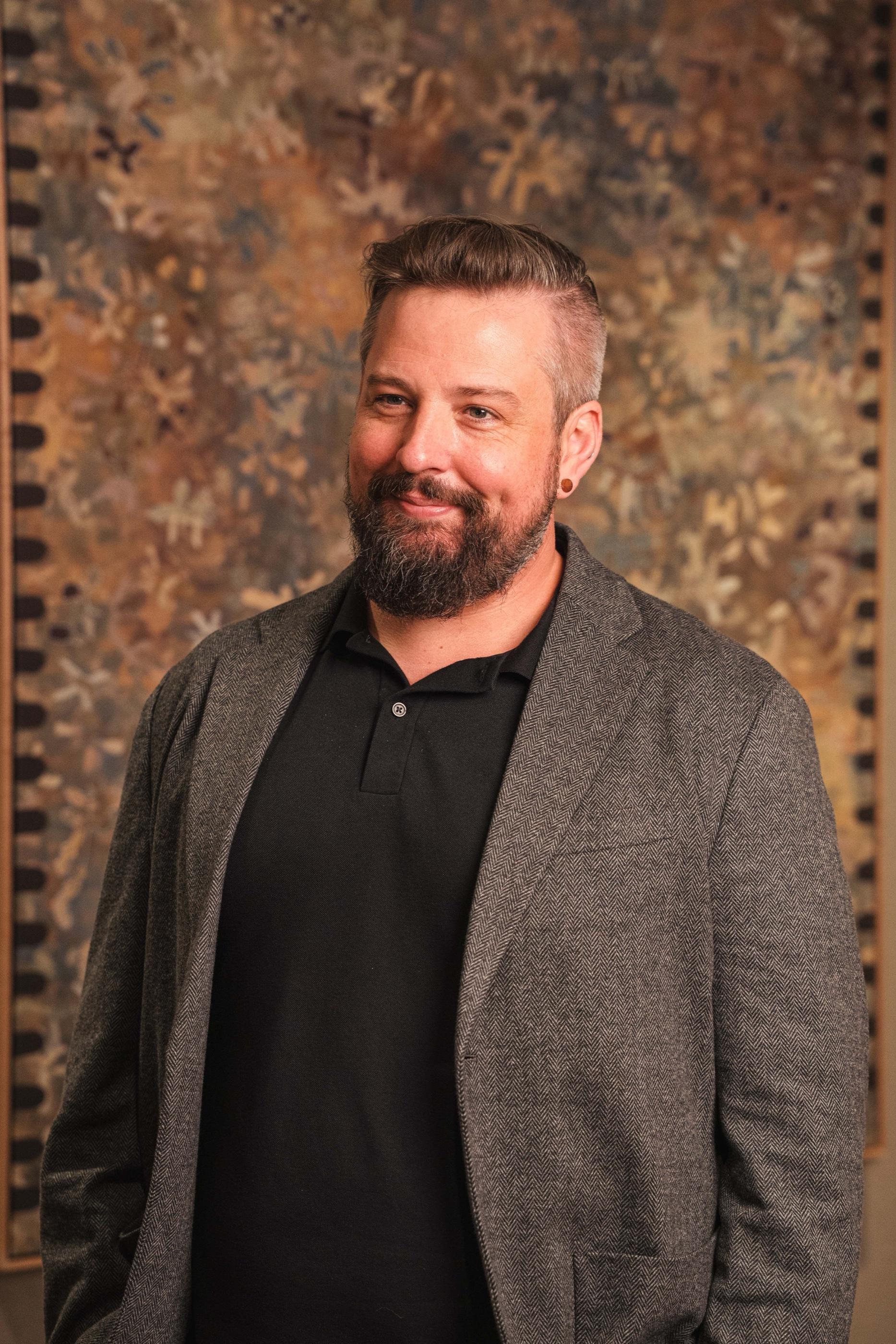 Portrait of an AKT Advisory founding partner in a grey jacket