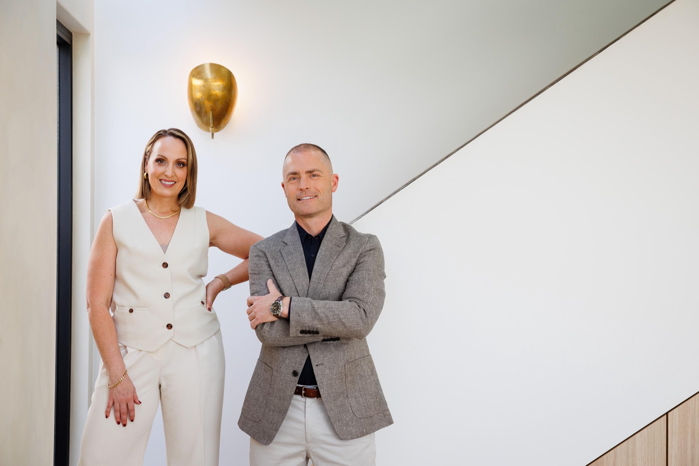 Nadija and Dan by a staircase in a light-filled home
