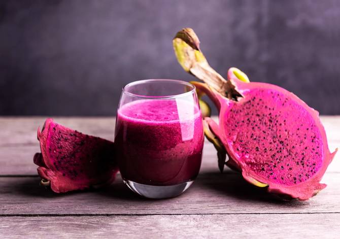 dragon fruit smoothies in glass and on wooden table