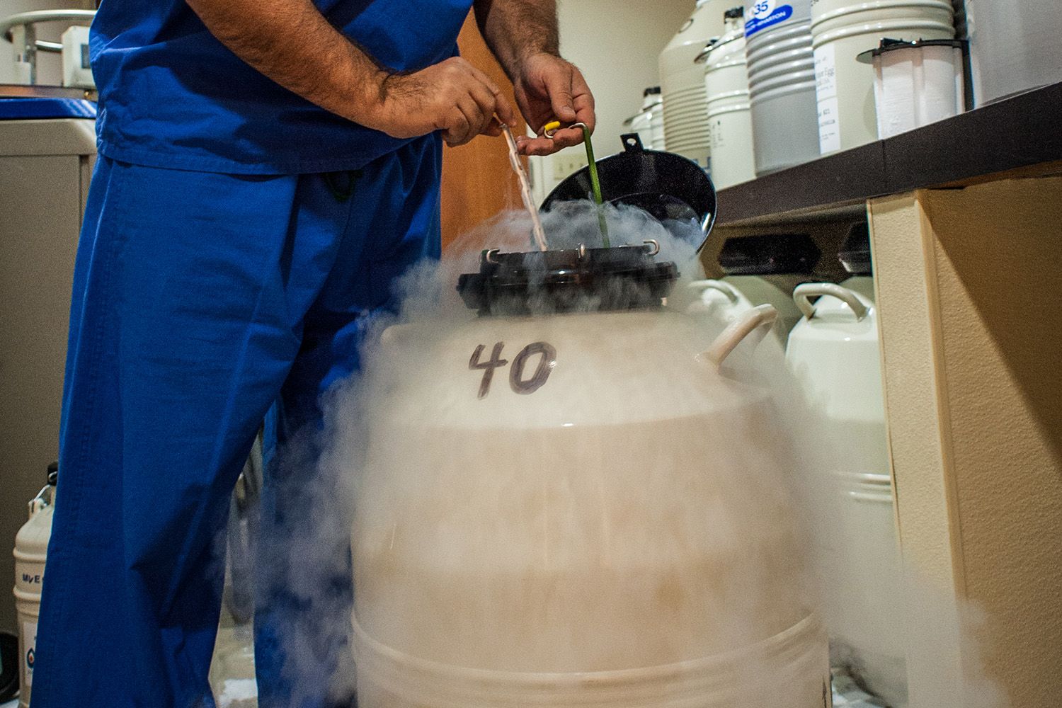 Medical looking barrel, gloved hands holding measuring devices, smoky vapor emits from barrel.
