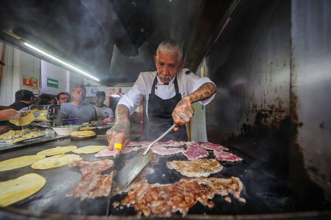 Griller Jacinto Rodriguez works preparing tacos during a visit to 'El Califa de Leon' on May 16, 2024 in Mexico City, Mexico.