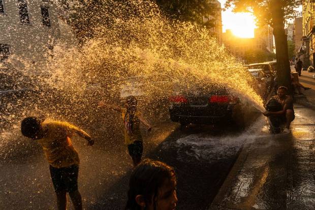 Cousins Miranda, 8, Elianna, 8, and Isabella, 10, cool off and play in water sprayed from a fire hydrant during hot weather on July 16, 2024 in the Washington Heights neighborhood of New York City