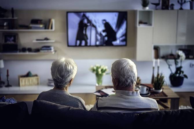 an older couple watching television together