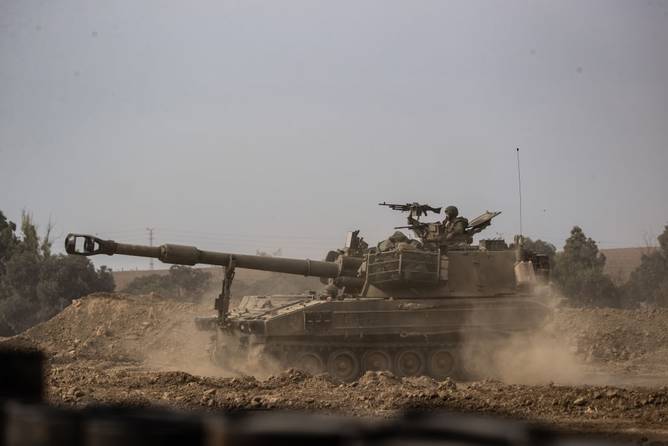  Israeli soldiers on a tank move near Gaza border