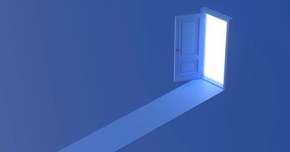 An open door with a blue background shining light through the opening