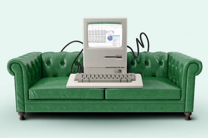 A desktop computer plugged into a green couch.