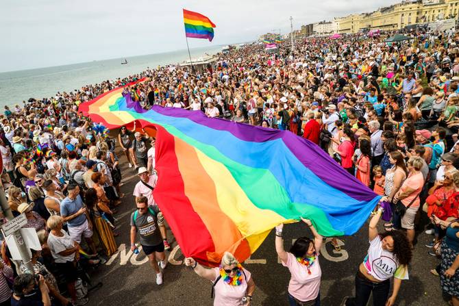 A giant rainbow Pride flag is carried along the sea front during Brighton Pride 2019.