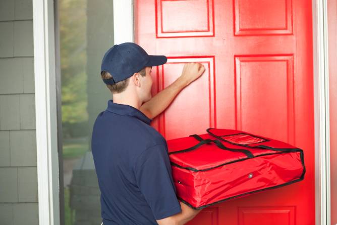 Image of a pizza delivery person knocking on a front door. 