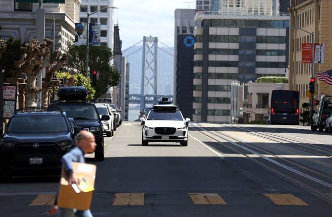 A Waymo autonomous vehicle drives along California Street on April 11, 2022 in San Francisco, California.